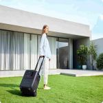 Mobile BLUETTI Elite 320 Powerstation mit Transportgriff vor modernem Wohnhaus