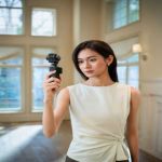 Content Creatorin hält die DJI Osmo Pocket 4P für eine mobile Vlogging- und Porträtaufnahme in der Hand